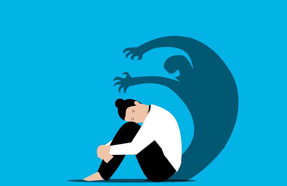 Cartoon of woman curled up, sad with an anxiety shadow behind her